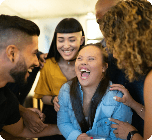 Girl with disability surrounded by friends laughing