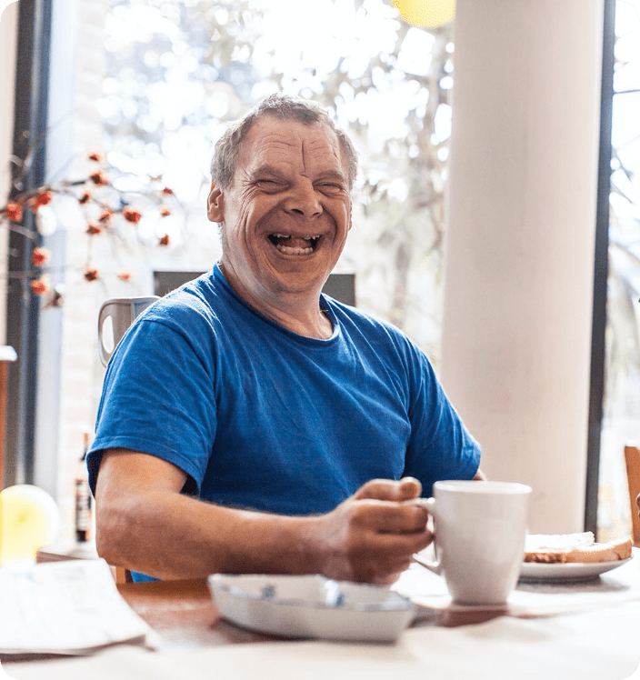 Happy man with disability drinking cup of tea