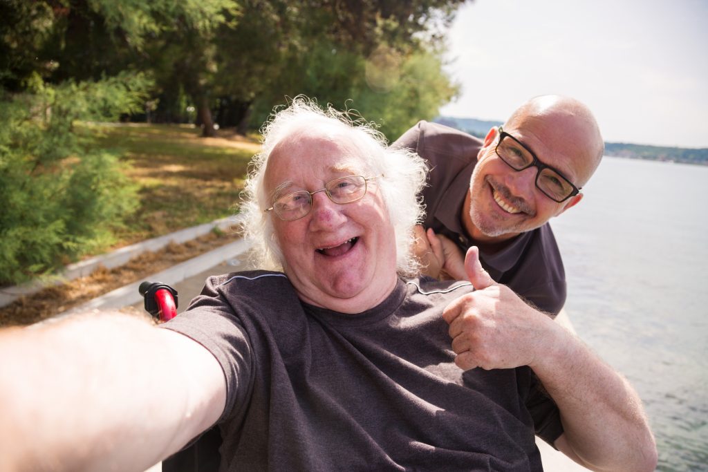 Man in wheelchair taking a selfie with his phone